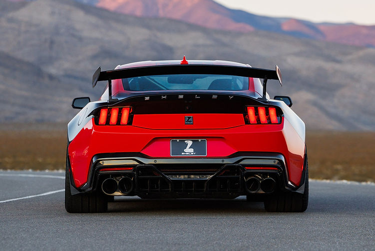 Rear view of the Shelby Super Snake-R showcasing quad exhaust tips, carbon rear diffuser, widebody arches and pedestal wing, with desert mountains in the background.