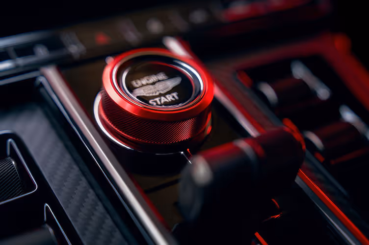Drive mode selector in anodised red, matching contrast stitching and seatbelts.