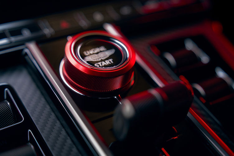 Drive mode selector in anodised red, matching contrast stitching and seatbelts.