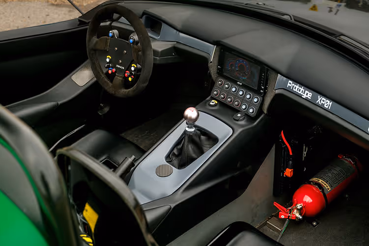 Zenos E10 RZ prototype interior showing race-style steering wheel, manual gear lever, and digital display.