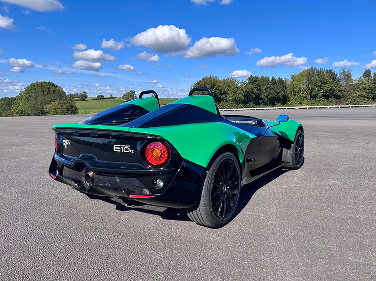 Rear view of the Zenos E10 RZ parked on tarmac, highlighting taillights, diffuser, and central exhaust.