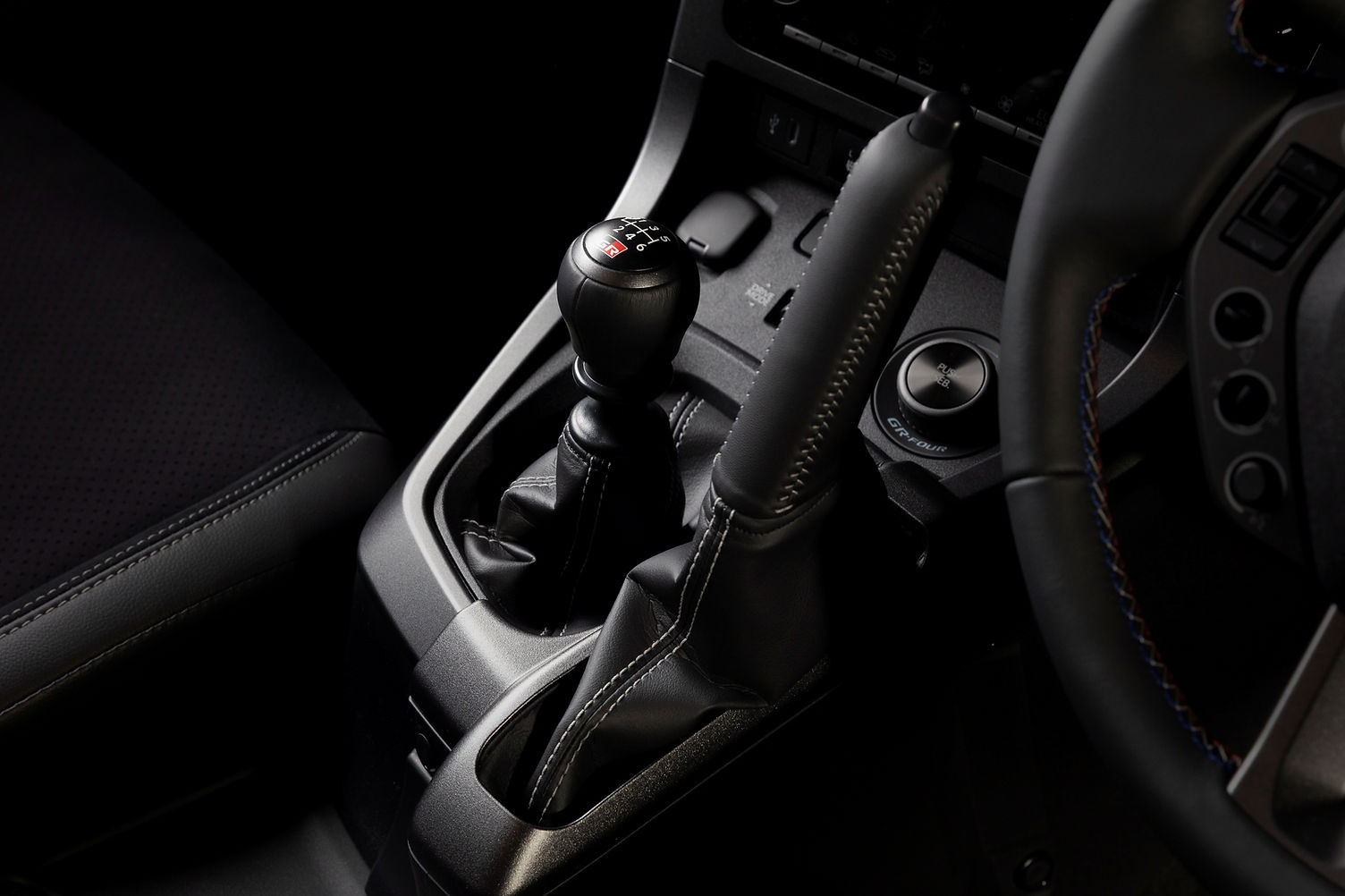 GR Yaris six-speed manual gearbox with vertical handbrake and tricolour stitching