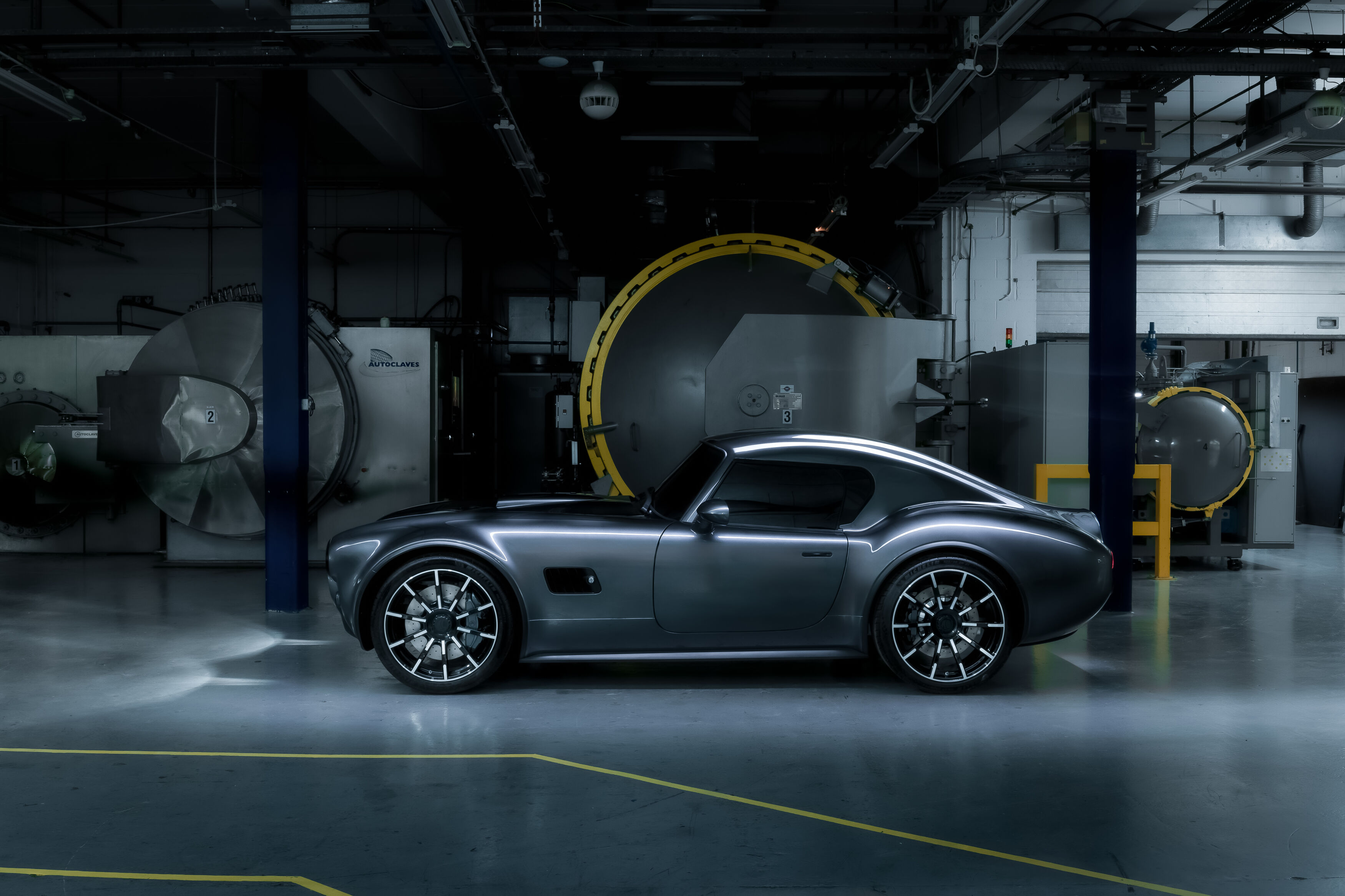 AC Cobra GT Coupe side profile, low lighting, factory setting infrom of autoclaves