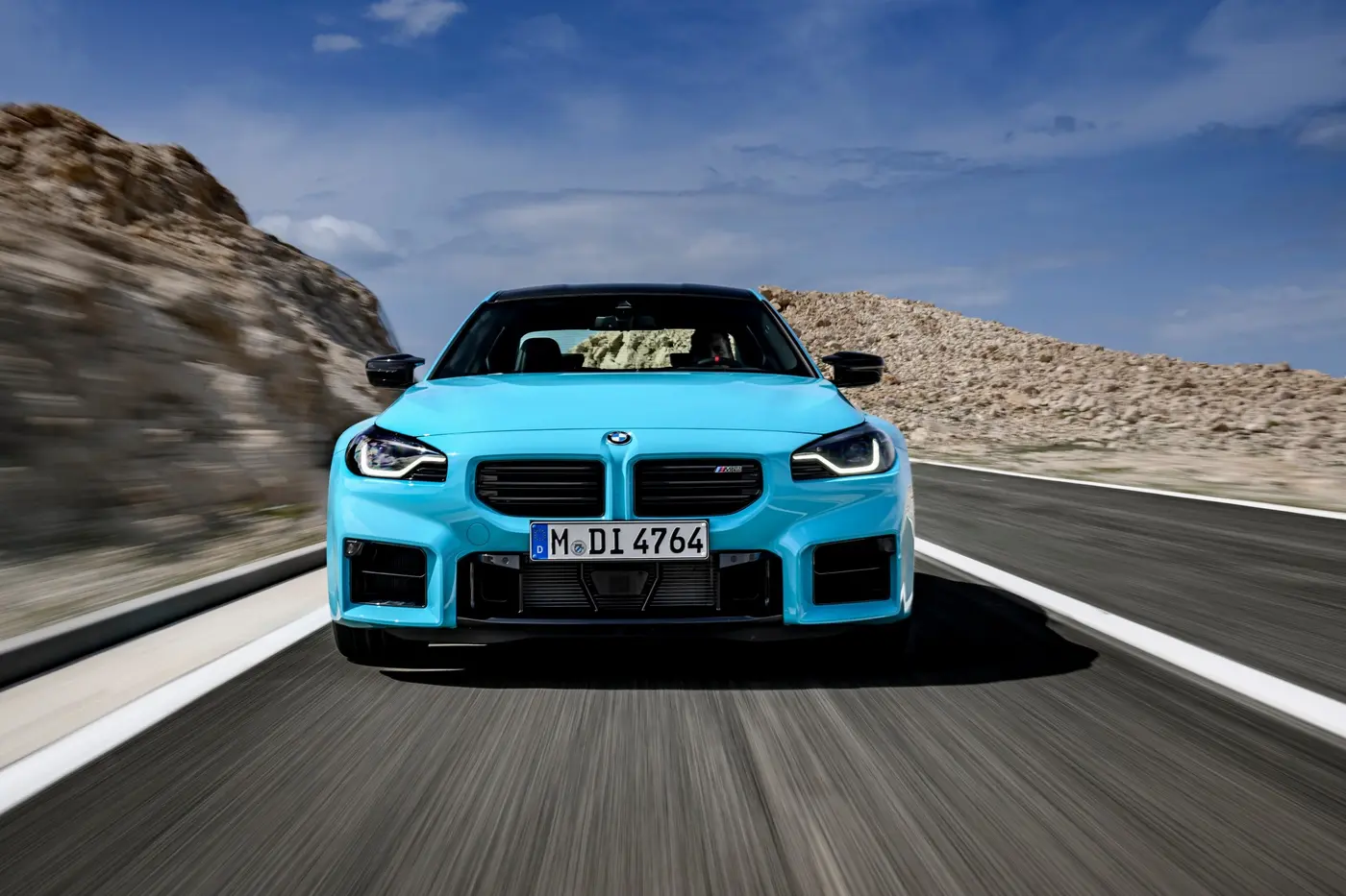 BMW M2 with M xDrive front action shot in Borusan Turkish Blue on mountain road