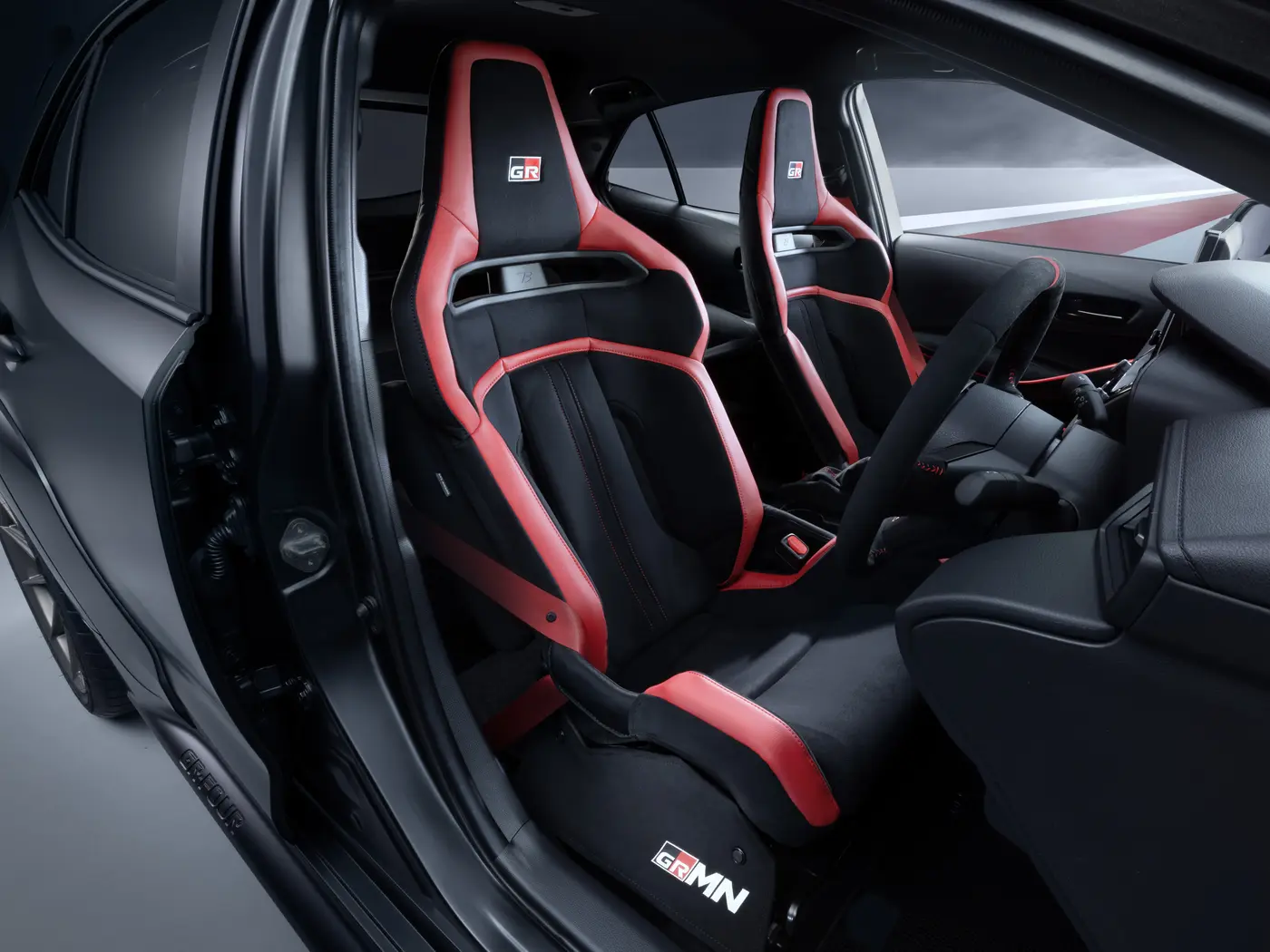 Toyota GRMN Corolla two-seat interior with red and black semi-bucket seats