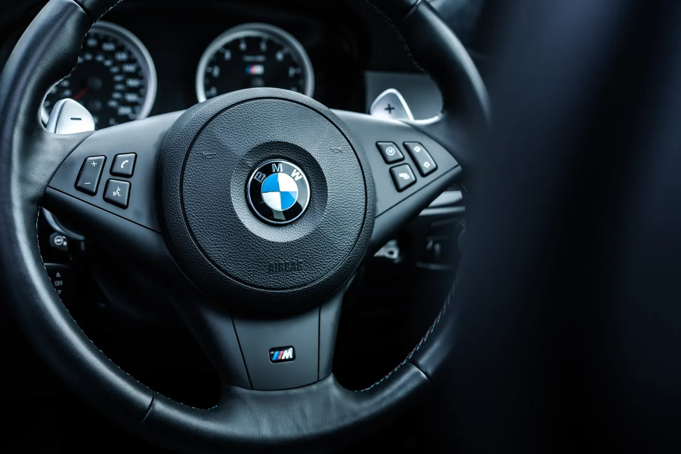 Rush magazine review of silver grey metallic E60 BMW M5. Close up detail image of leather steering wheel with oversized rim