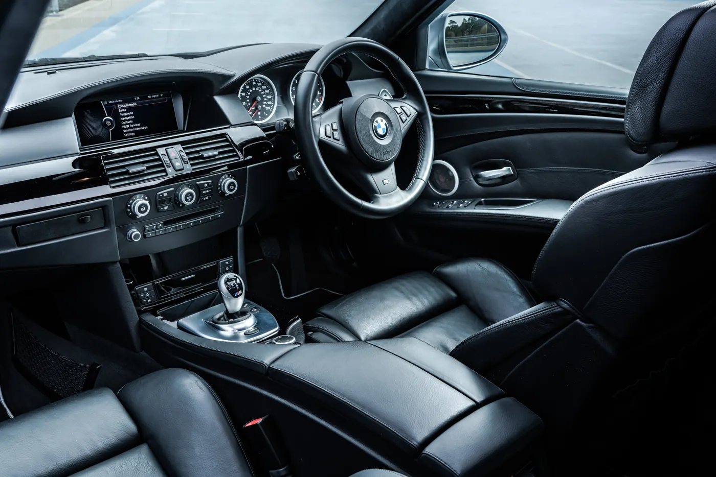 Rush magazine review of silver grey metallic E60 BMW M5. Interior centre console shot taken at a rooftop parking garage on an overcast day
