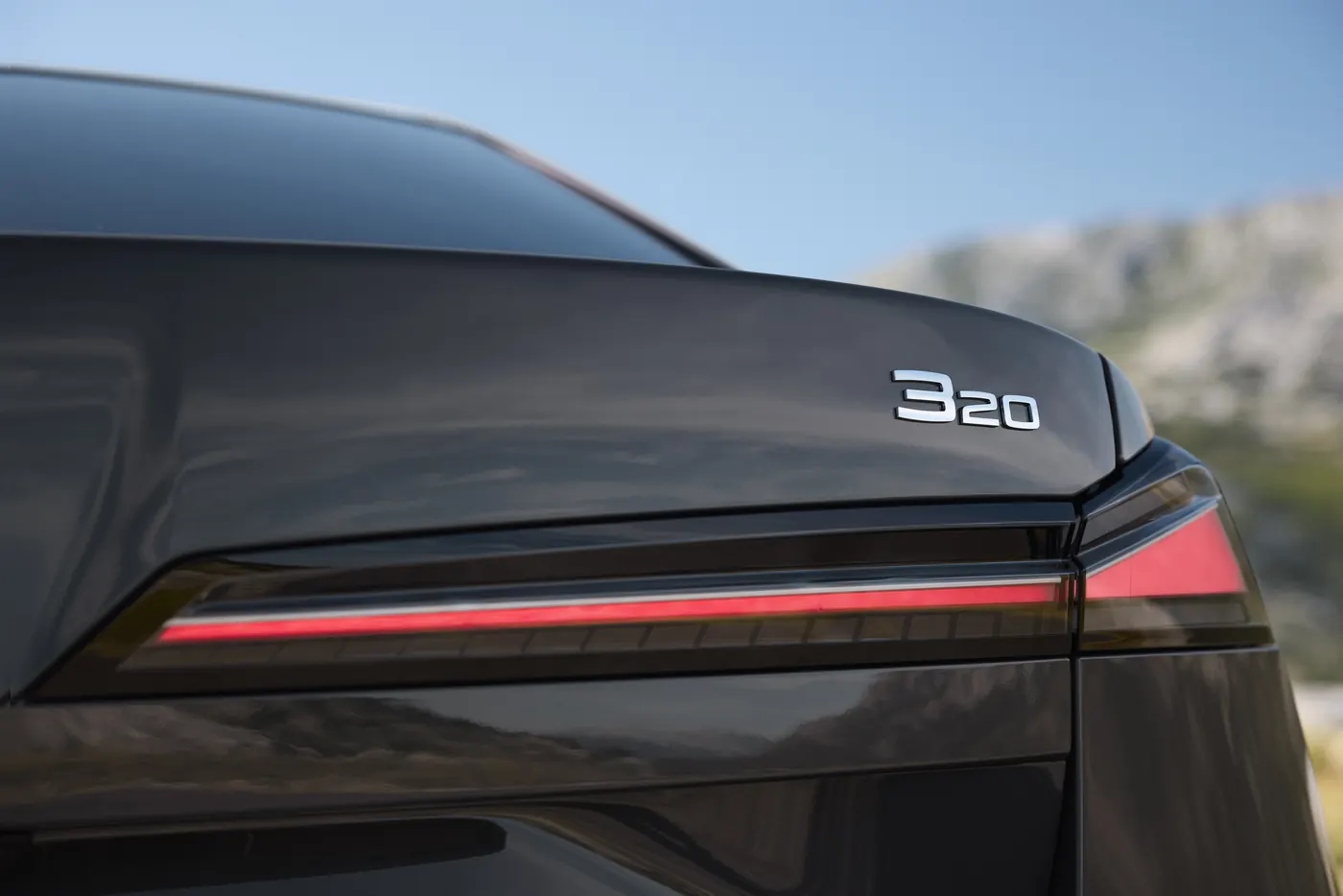 New BMW 320 G50 in grey, close-up of the 320 boot badge and full-width LED tail light