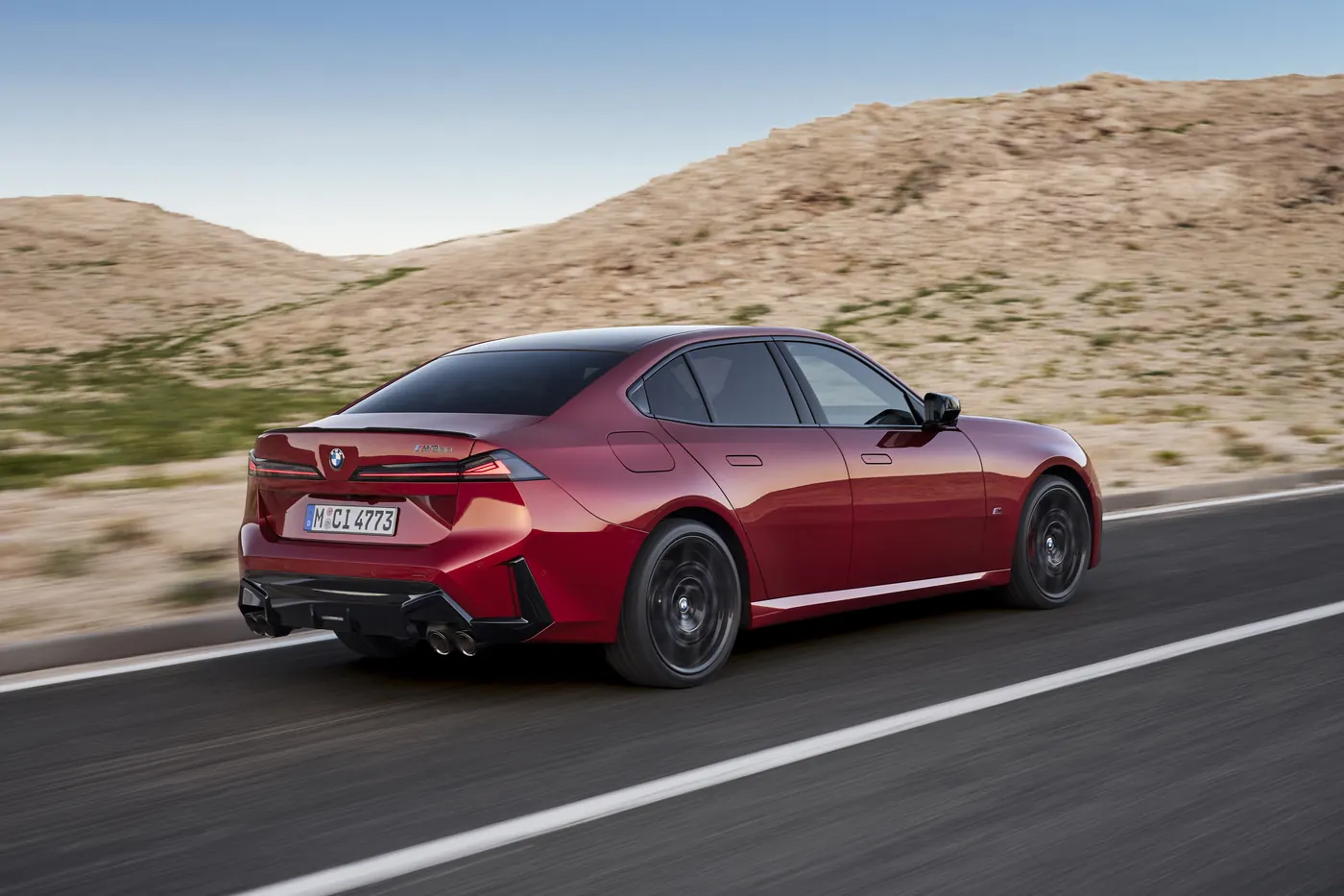 Fire Vegas Red BMW M350 xDrive driving, rear three-quarter with quad exhausts and boot lip spoiler