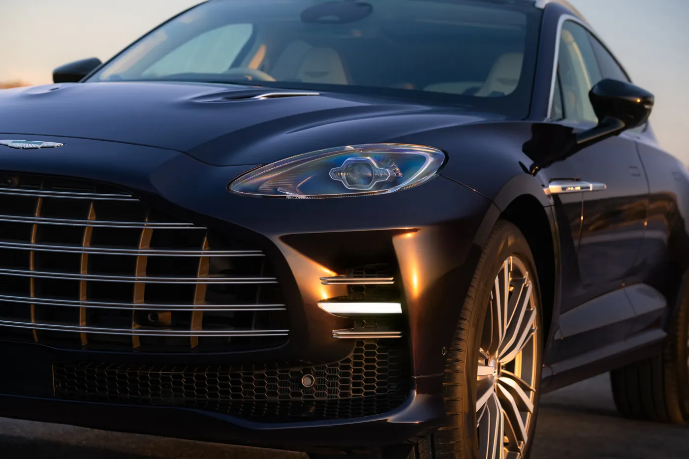 Close-up of the Aston Martin DBX GT headlight, with the grille bars carried across the flanking vent and daytime running light