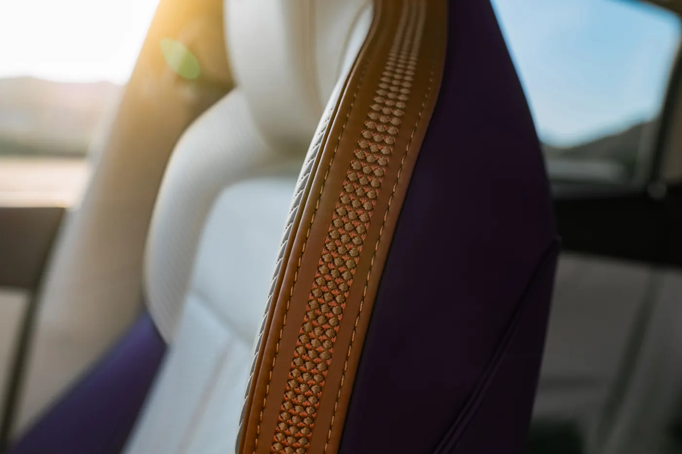 Close-up of an Aston Martin DBX GT seat bolster in tan leather, with woven detail and contrast stitching