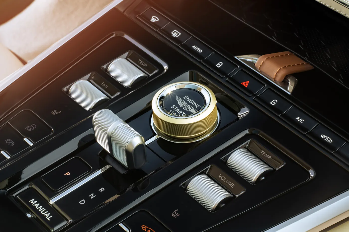 Close-up of the Aston Martin DBX GT centre console, showing knurled metal controls and the engine start button