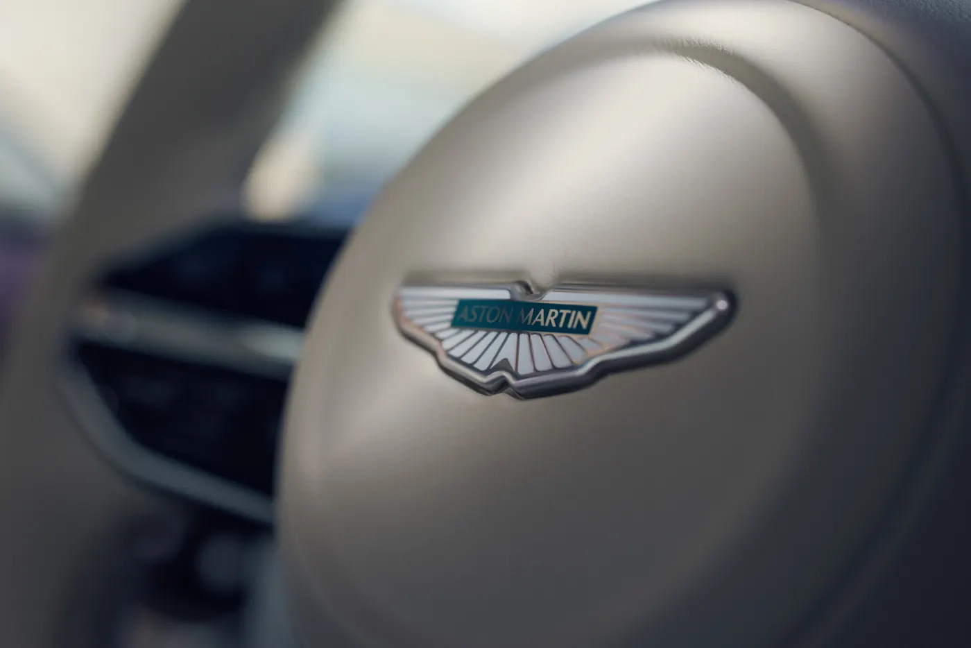 Close-up of the Aston Martin winged badge on the DBX GT steering wheel