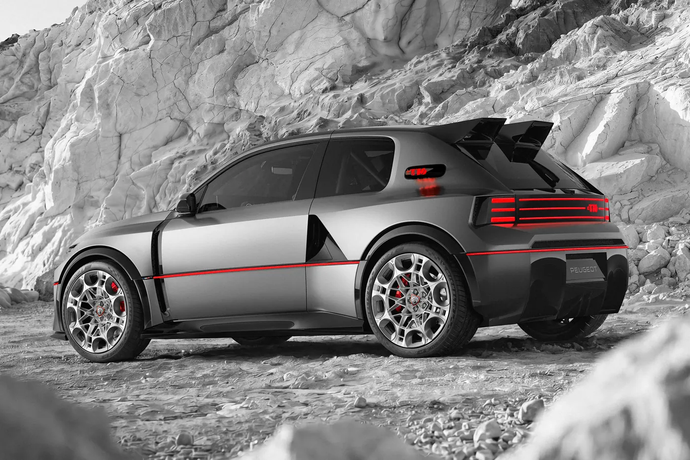 Peugeot E-T16 Concept in front of a pale rock face, showing the rear-wheel intake and red body line.