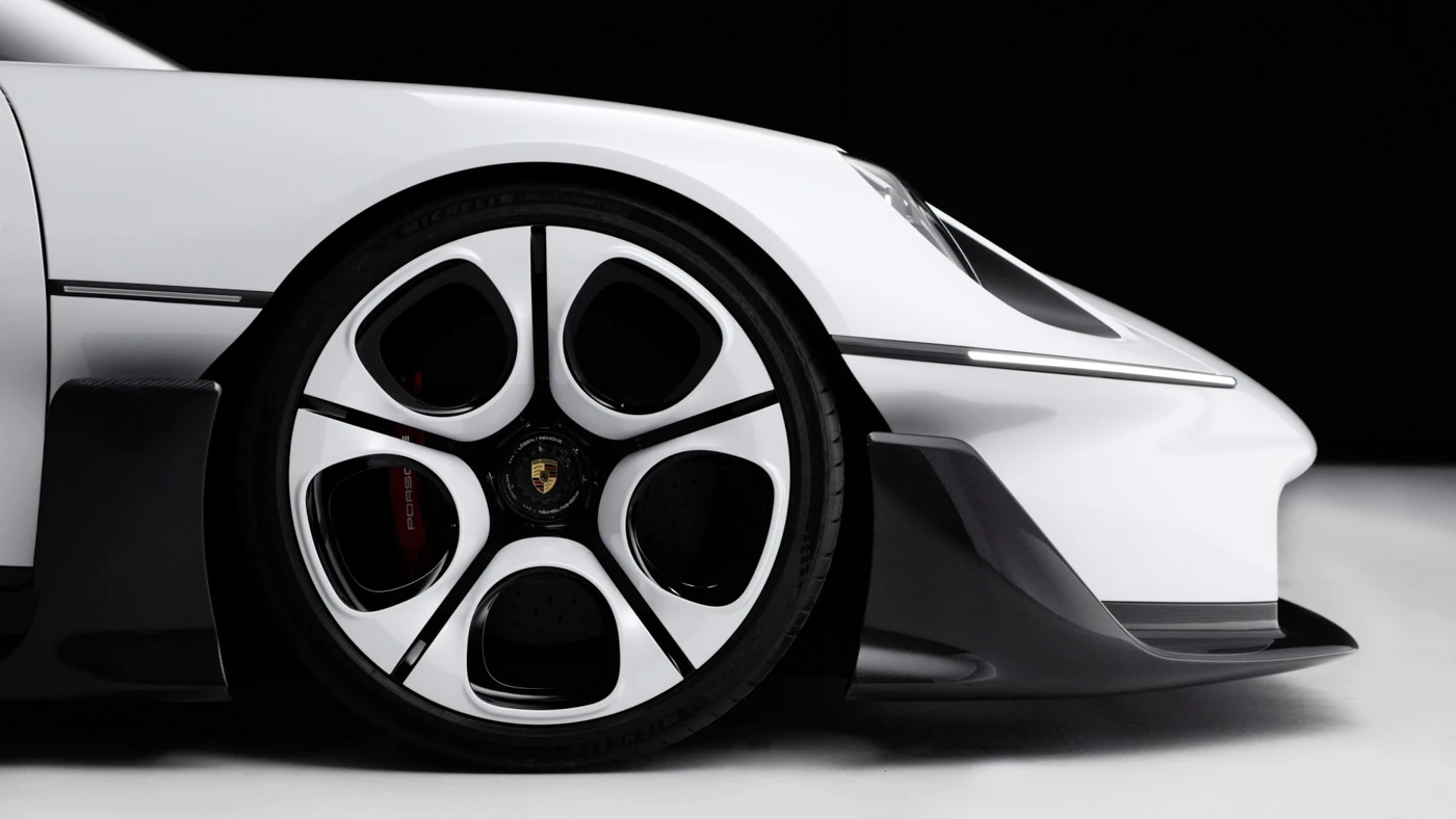 Close-up of the Mission S front wheel, with white five-spoke design, red brake caliper and carbon front splitter