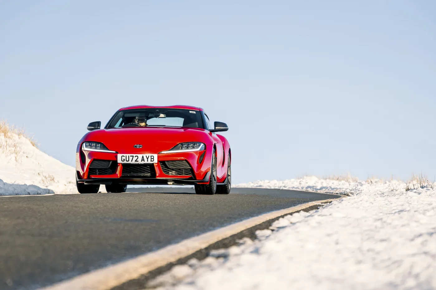 Toyota Supra manual review Rush Magazine - red A90 Supra driving through Snowdonia National Park framed by snow capped mountains