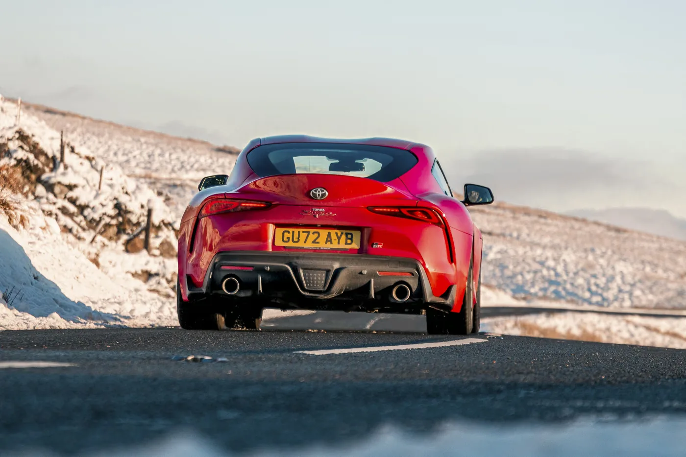 A90 Toyota GR Supra 3.0 Manual Review Rush Magazine rear panning shot, snow covered mountains brackdrop