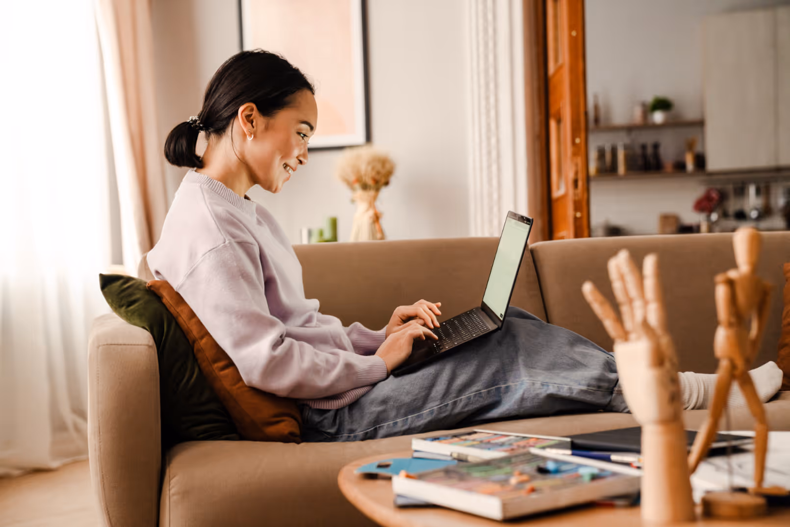 Woman on laptop sitting on sofa stock image