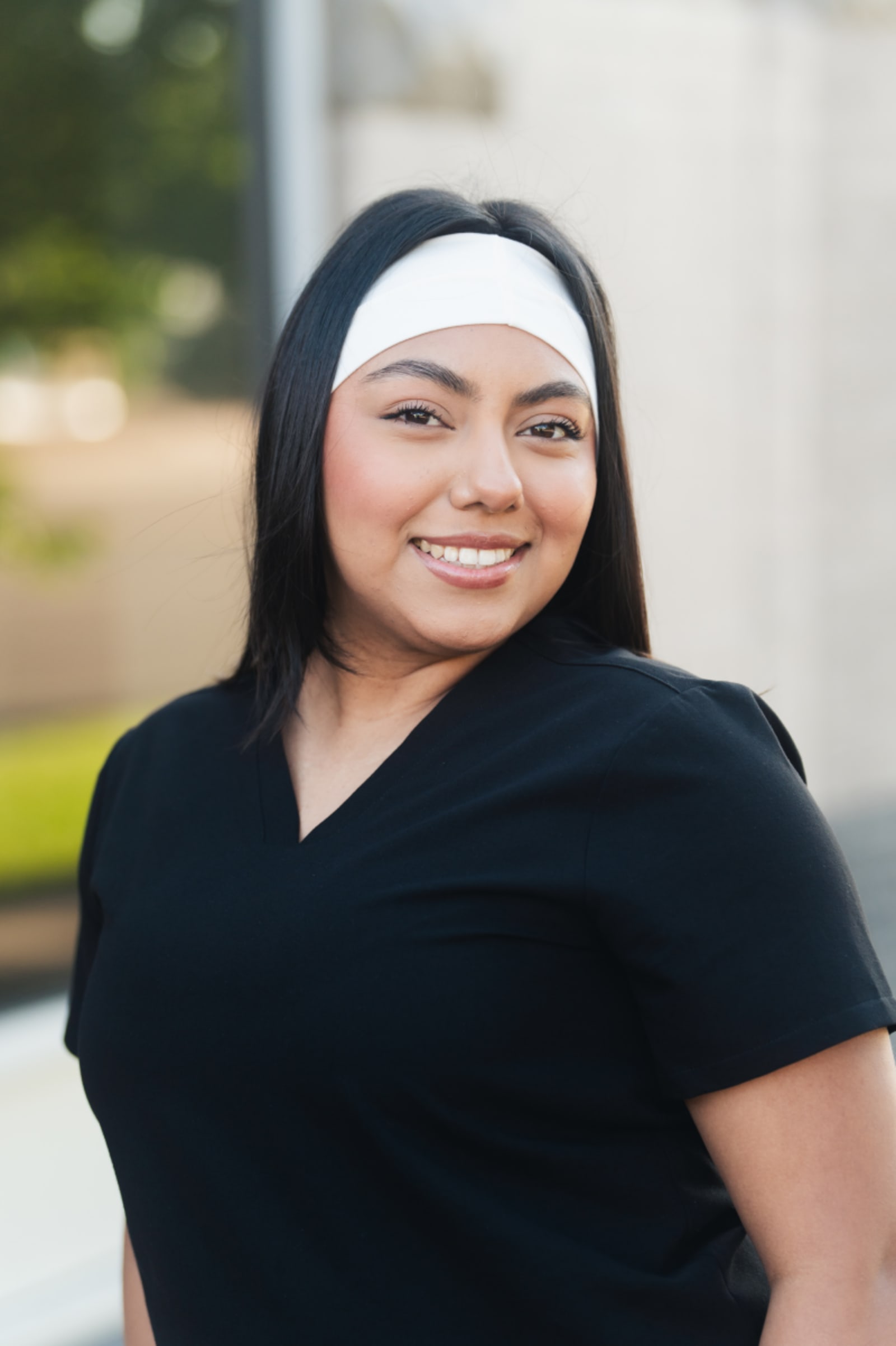 Female pediatric dentist smiling outdoors in professional headshot