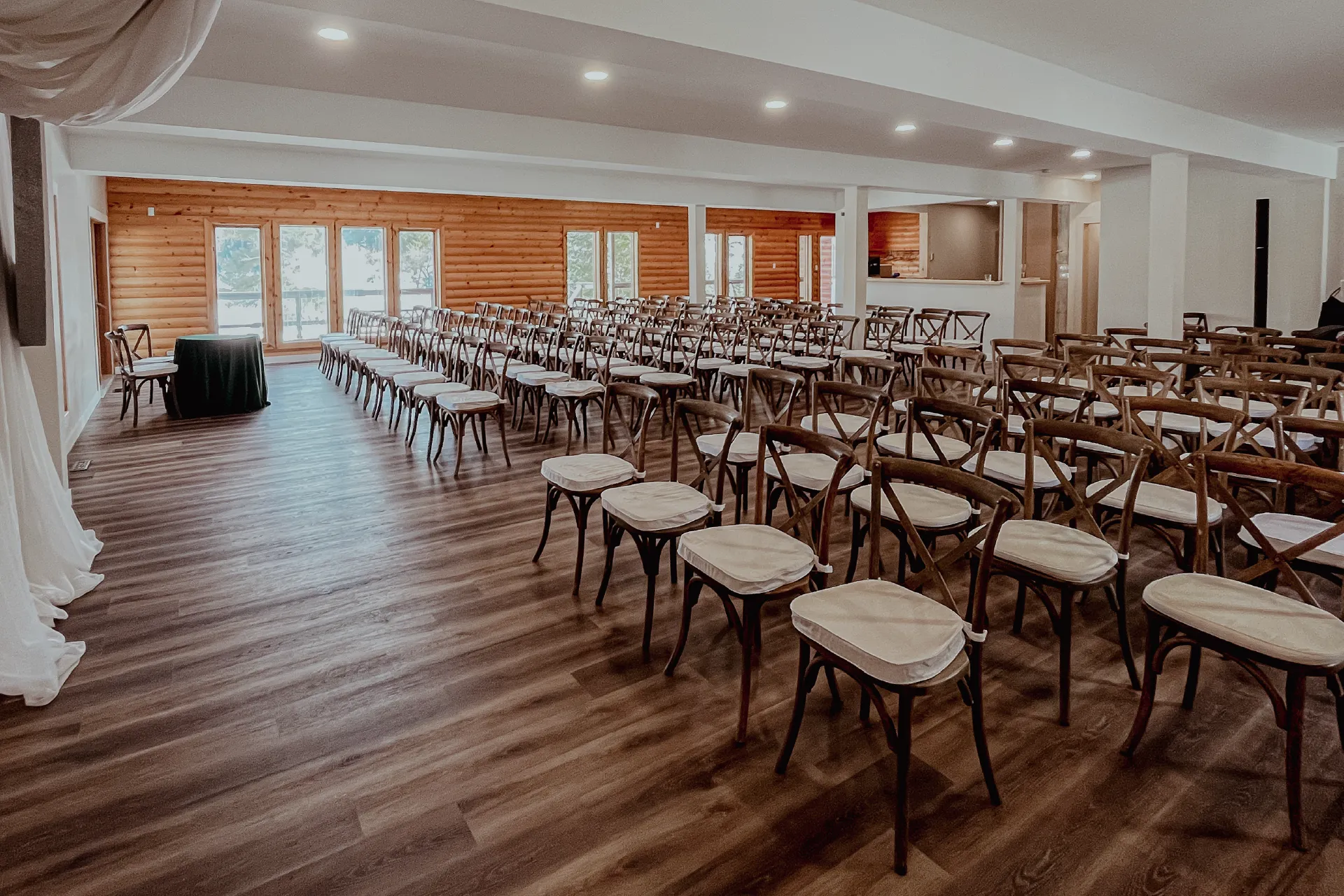 Indoor lodge event space set with rows of chairs facing a ceremony table.