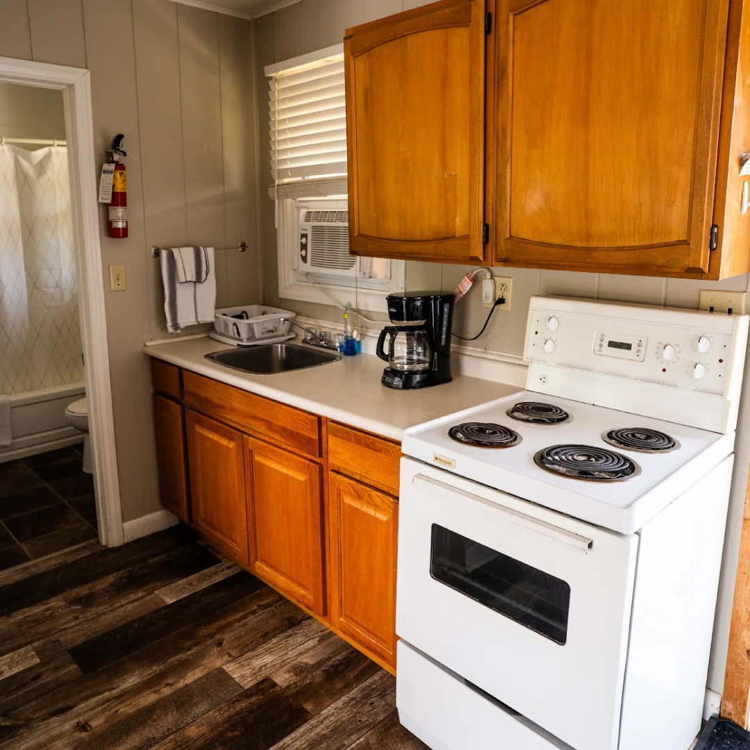 Exterior of the Dockside Cabins with picnic tables, barbecues, and cabin doors facing a shared grassy area.