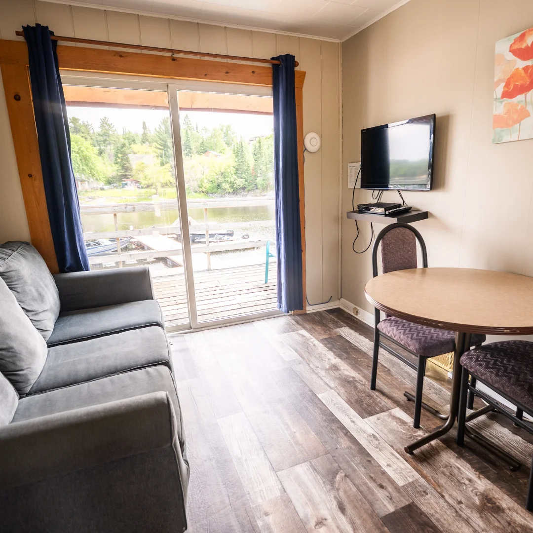 Exterior of the Dockside Cabins with picnic tables, barbecues, and cabin doors facing a shared grassy area.