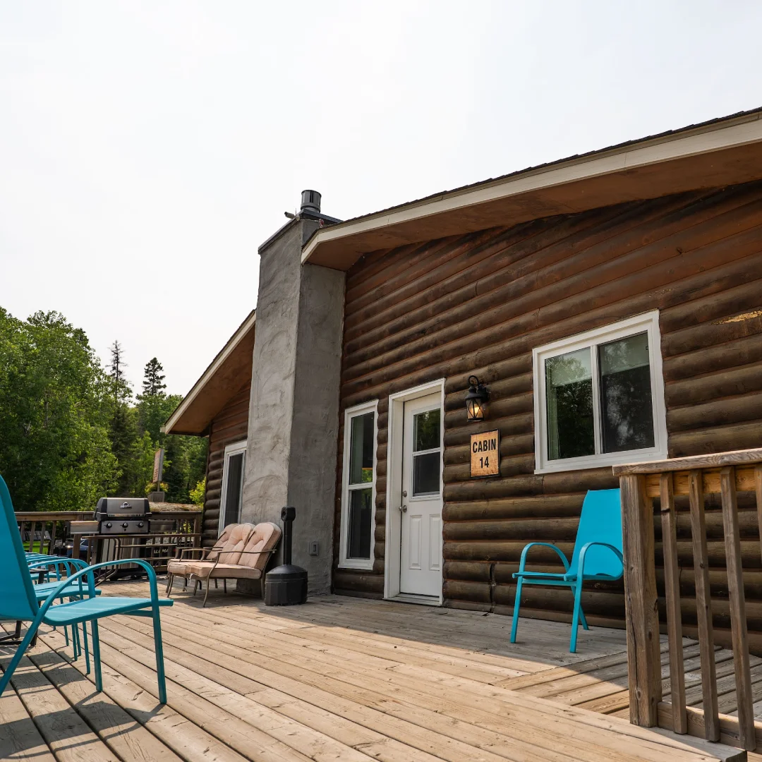 A modern blue house nestled among lush green trees and hills under a cloudy sky, surrounded by tranquil nature.