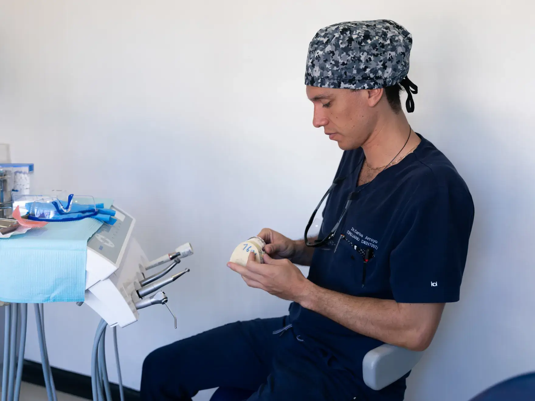 a man in scrubs sitting on a chair next to a table