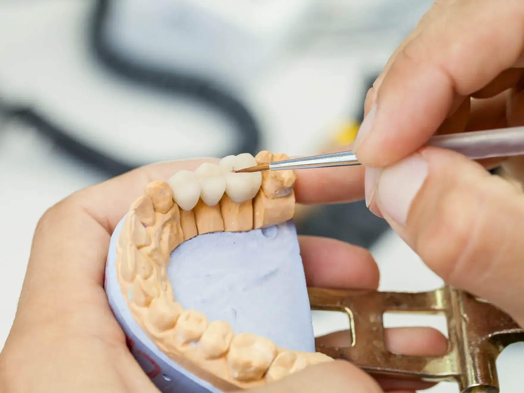a person cutting a tooth with a pair of scissors