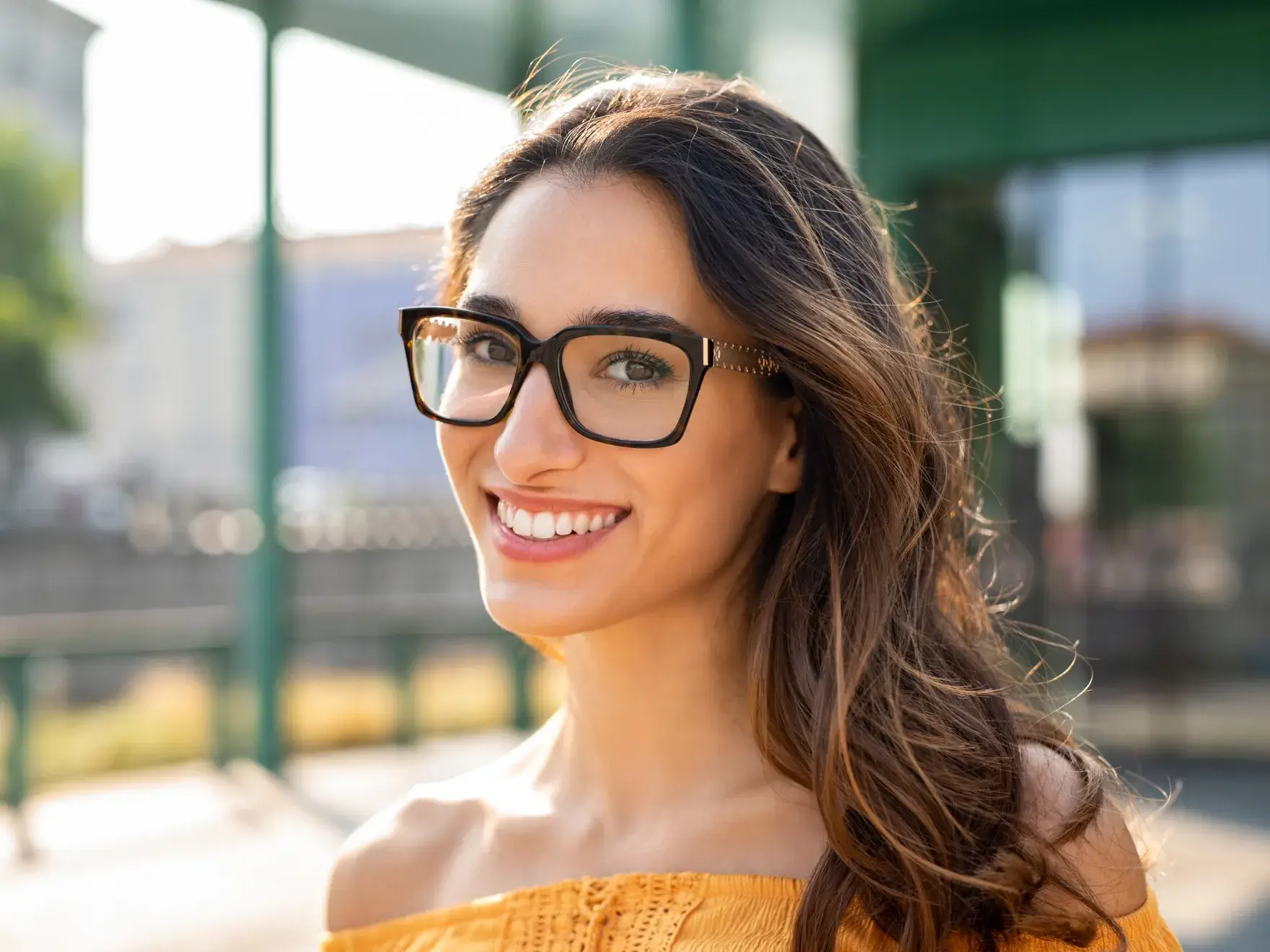 a woman wearing glasses and smiling for the camera