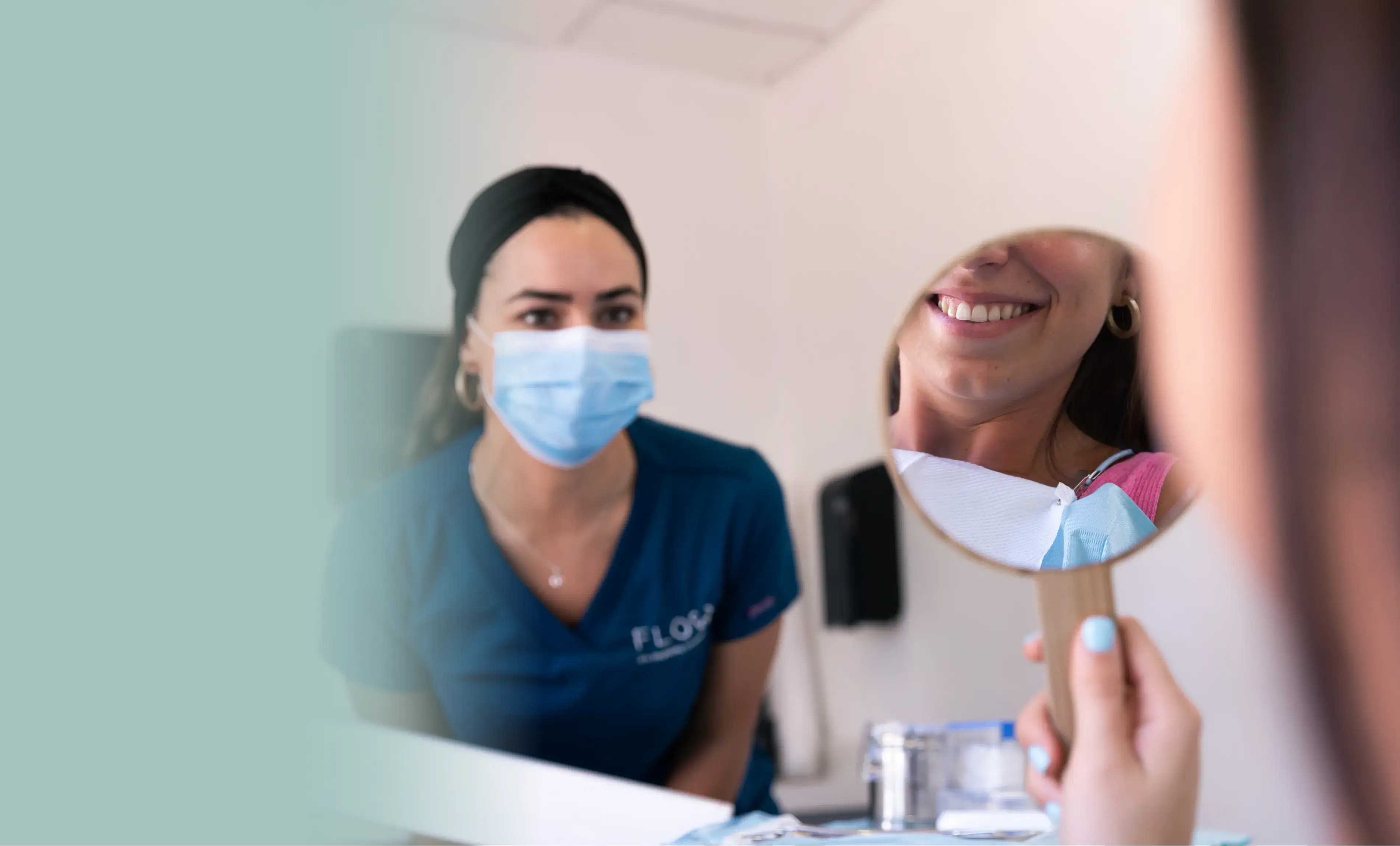 a woman in a blue shirt is looking in a mirror