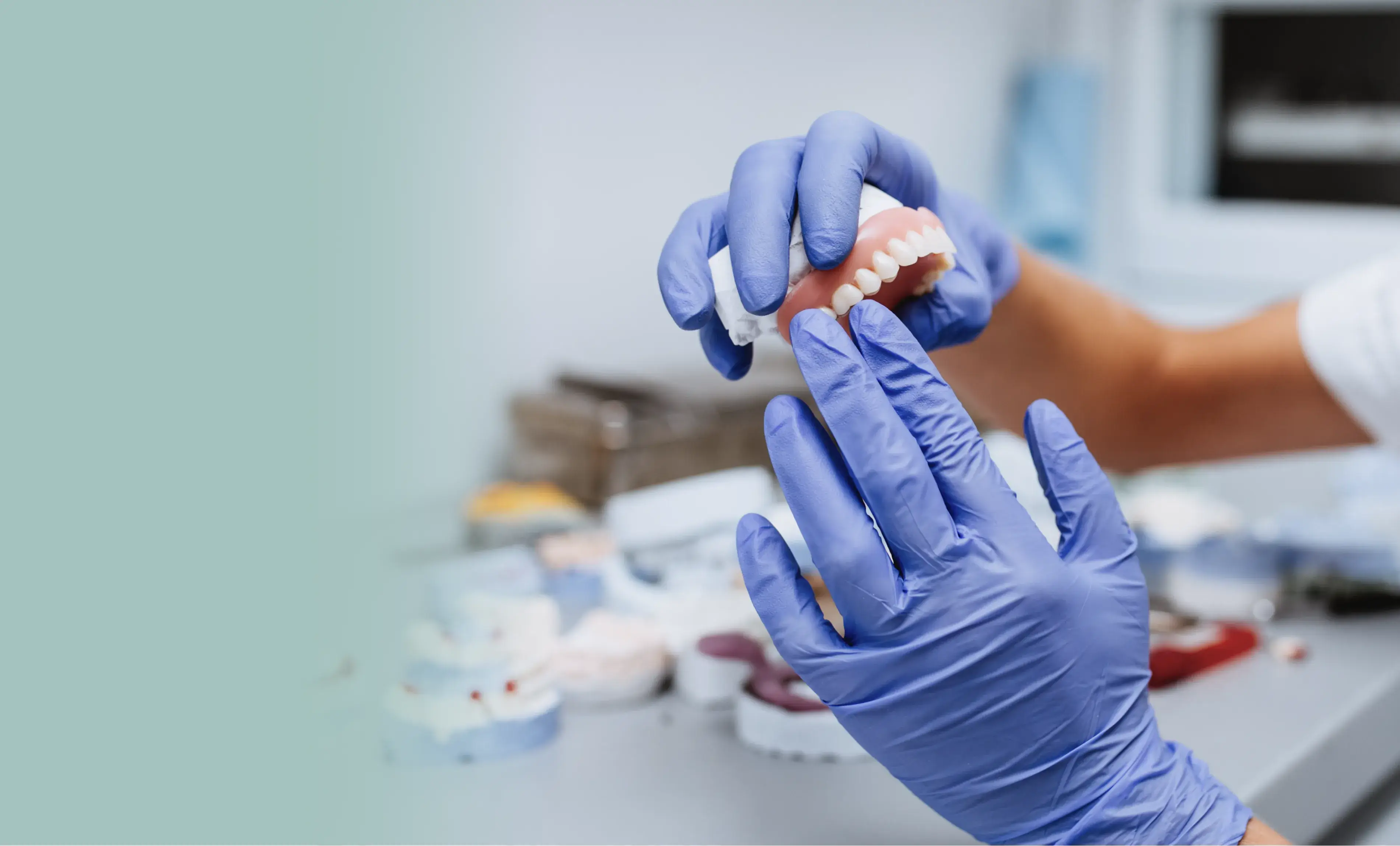 a person in blue gloves is holding a toothbrush