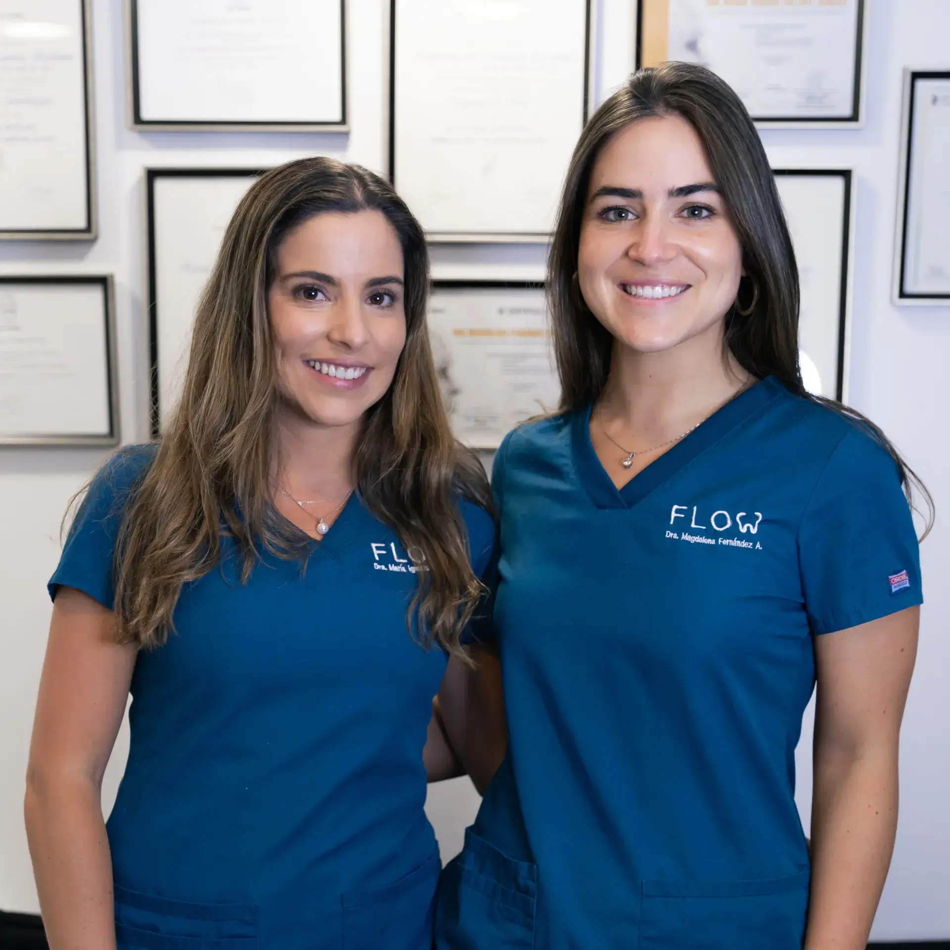 two women in blue scrubs standing next to each other