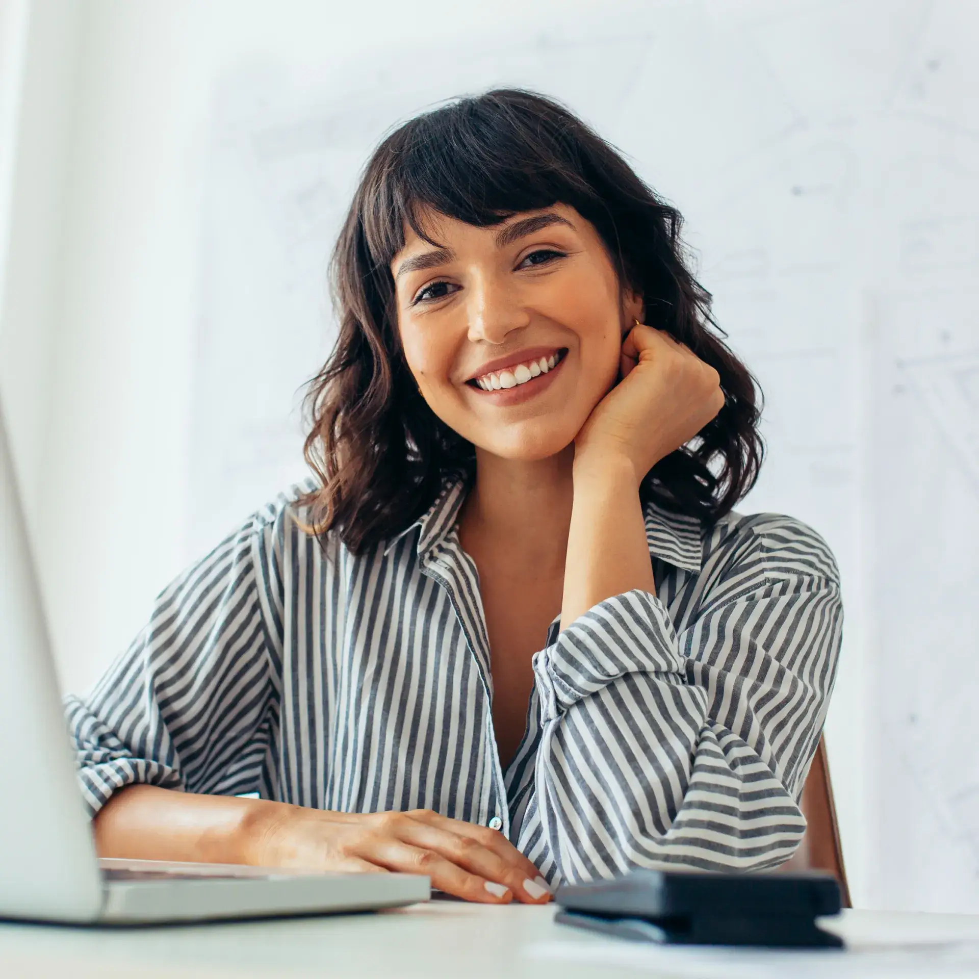 a woman sitting in front of a laptop computer