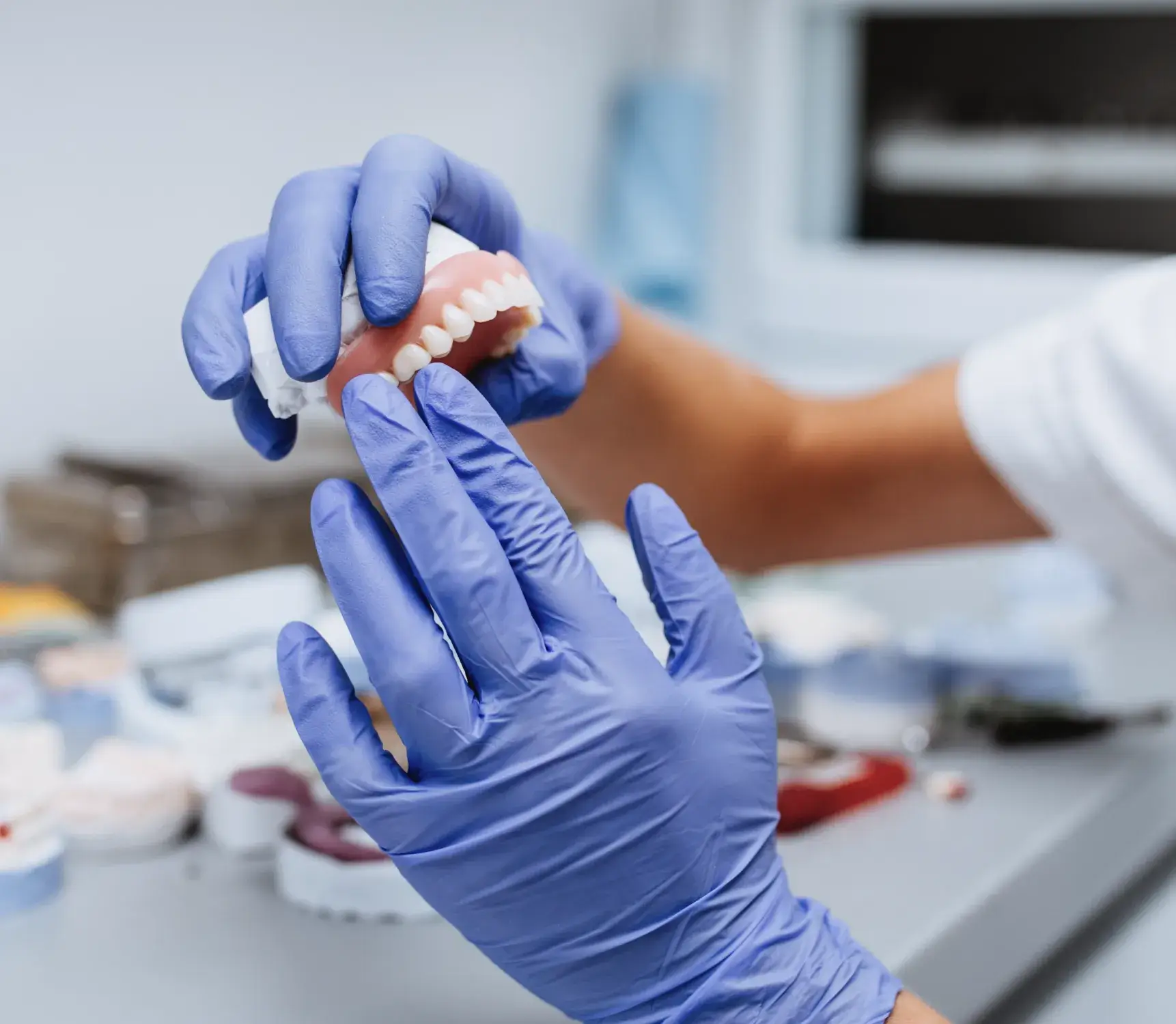 a person in blue gloves is holding a toothbrush
