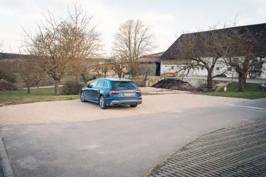 Ein Auto steht auf einem Schotterparkplatz.