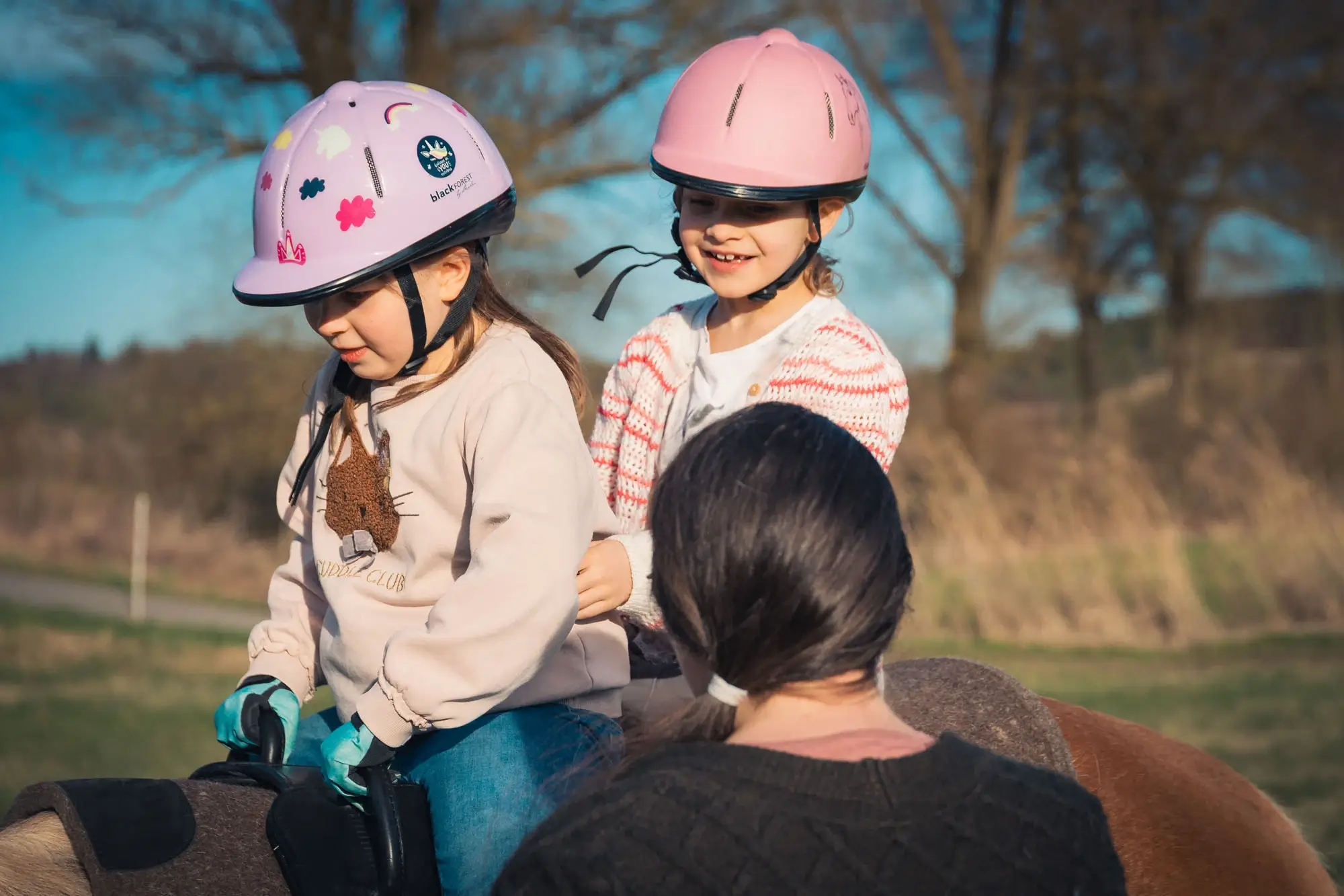 Zwei Kinder sitzen gemeinsam auf einem Pferd.