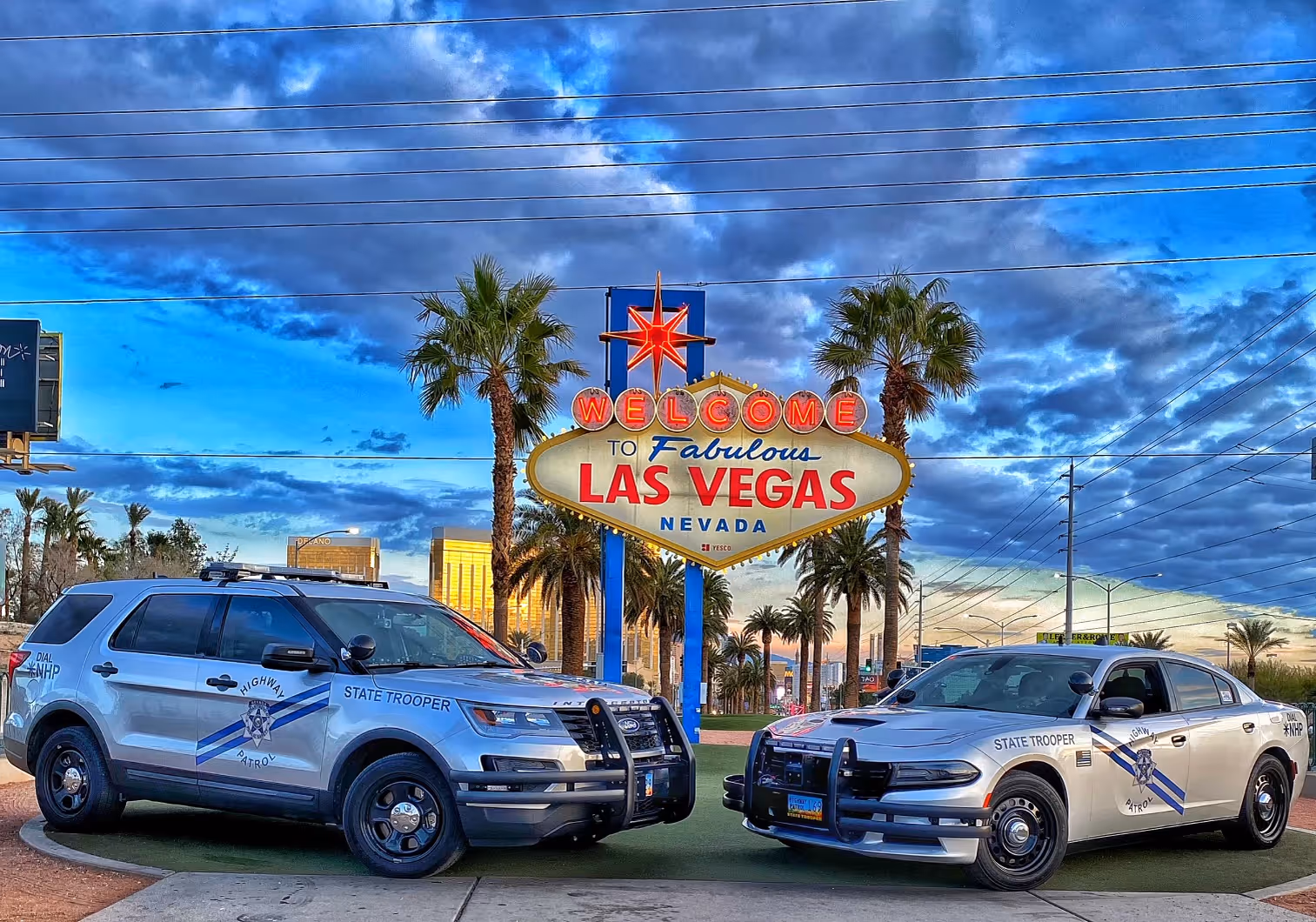 NV police vehicles in front of Las Vegas sign