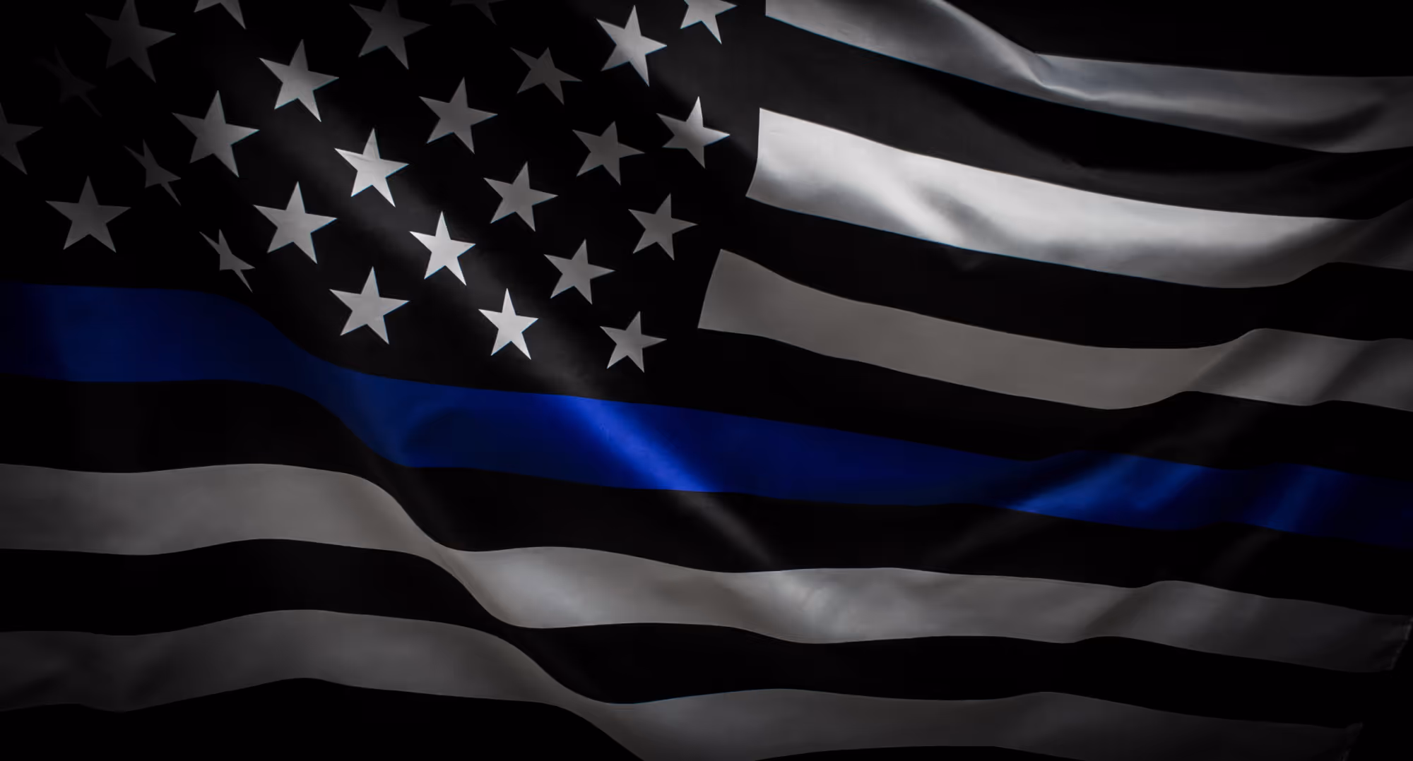 Black and white American flag with a single horizontal blue stripe representing the Thin Blue Line.