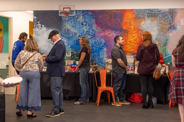 People standing in line at event with colorful geometric urban mural backdrop
Studio 37 Photography | Lora Bong