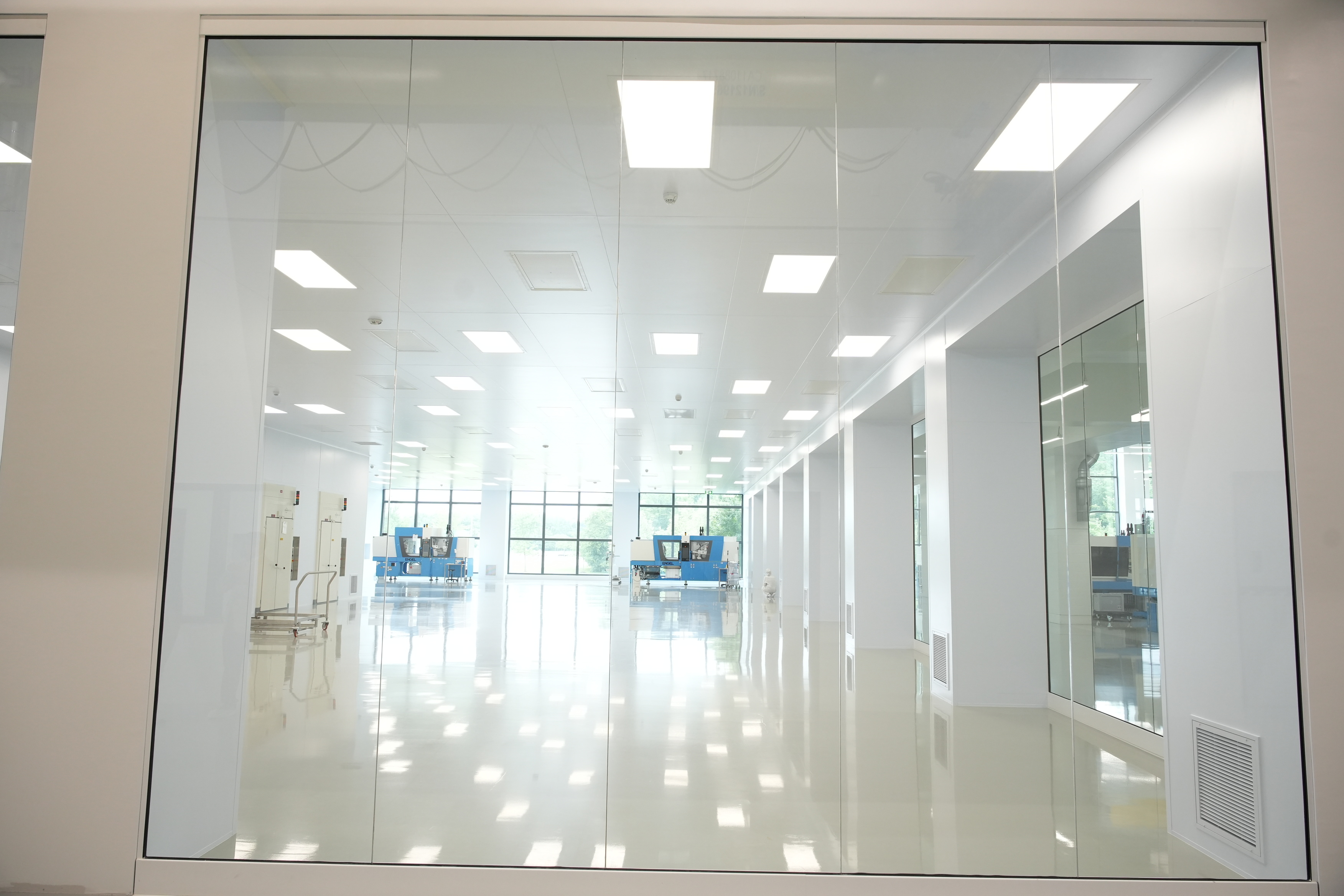 Bright glass-walled corridor with continuous LED ceiling panels in a finished ISO Class 8 facility supplied by Moddulx
