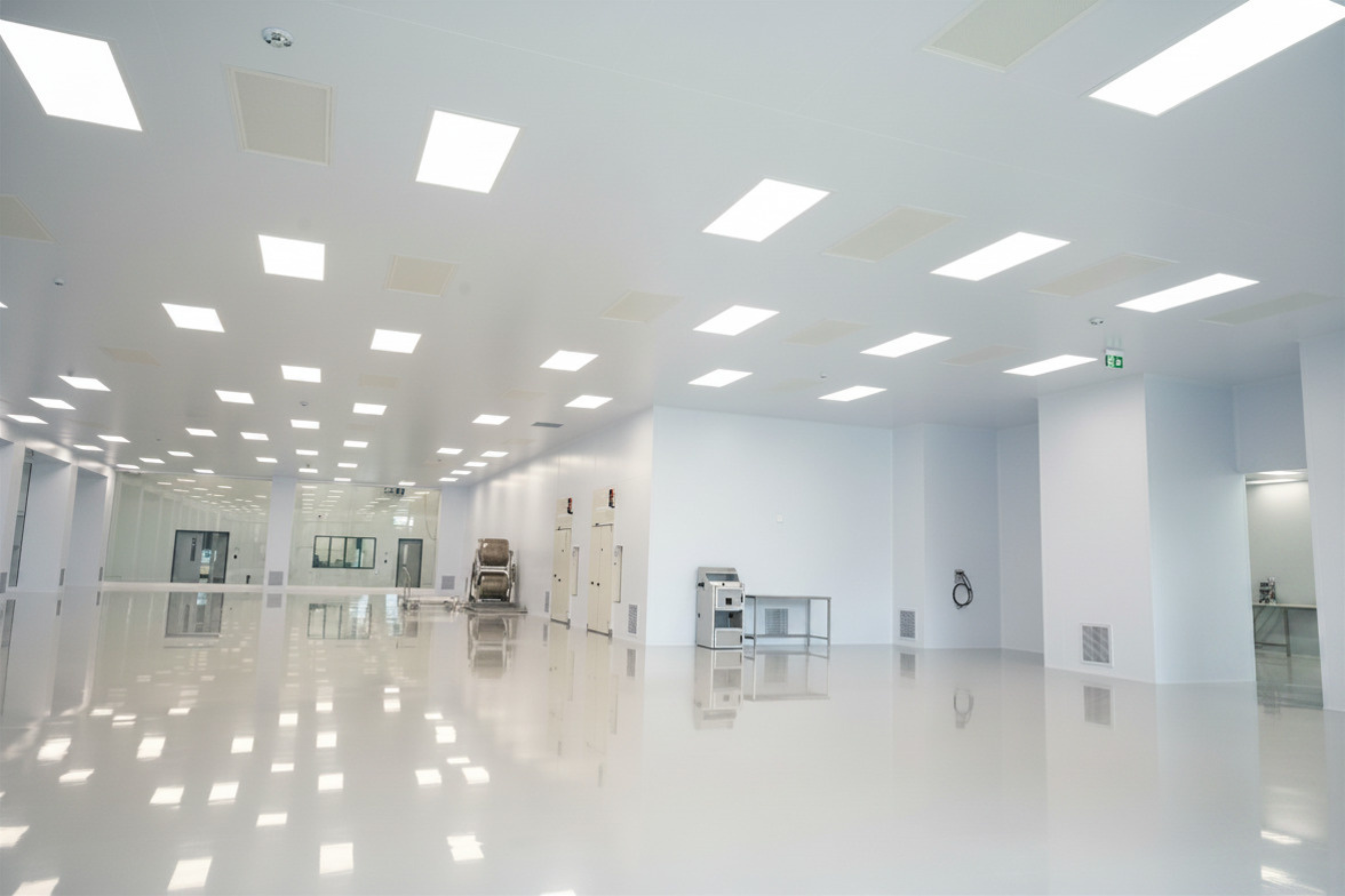 Cleanroom glass partition wall system overlooking production equipment in a finished ISO Class 8 space — buy cleanroom wall panels factory-direct from Moddulx