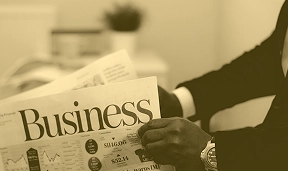 A man holding a newspaper with a heading Business