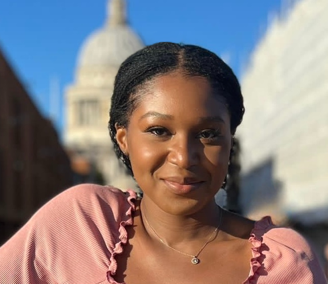 picture of a person outside with a building behind them