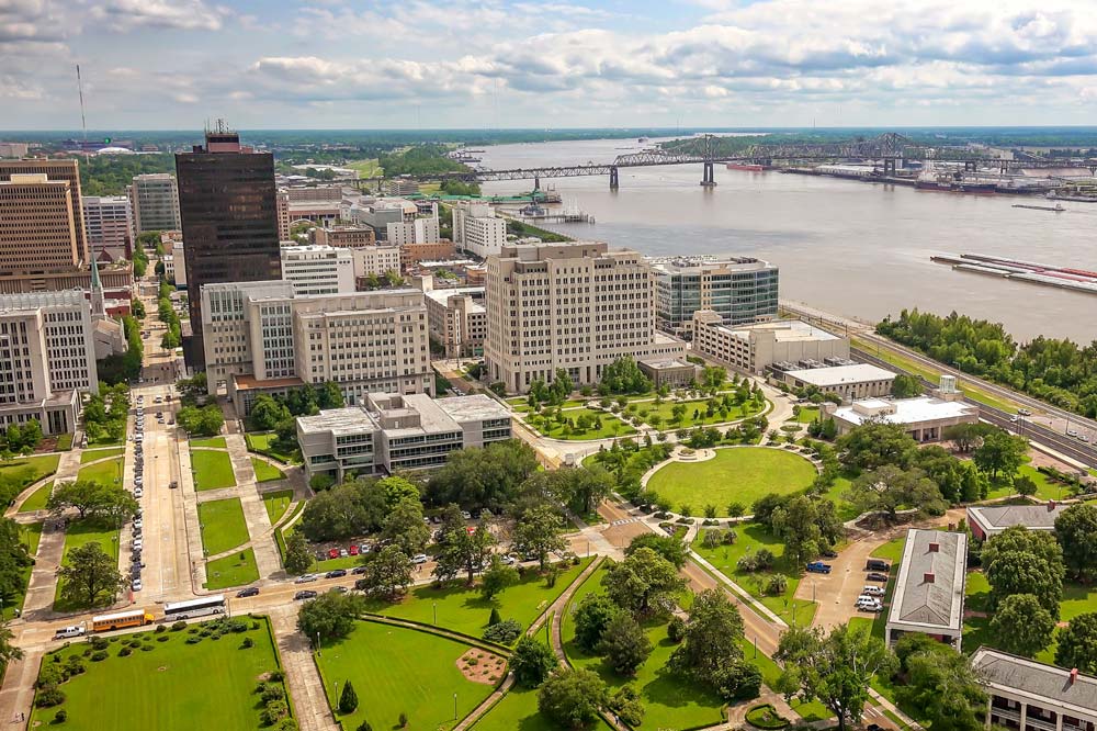 Aerial view of downtown Baton Rouge with government buildings, Repentance Park, the Mississippi River, and the Interstate 10 bridge