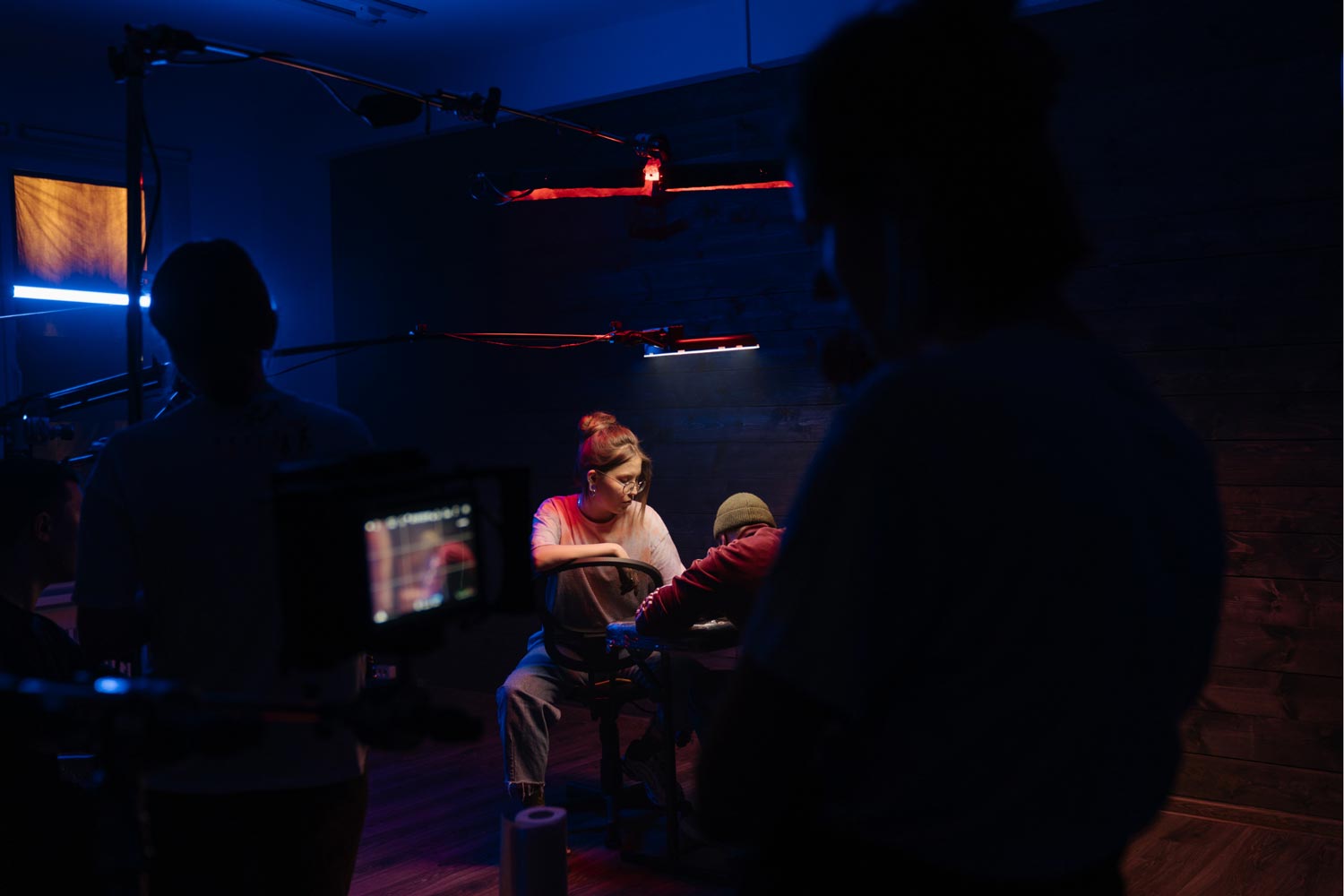 Extrast being filmed on a stage with lights all around