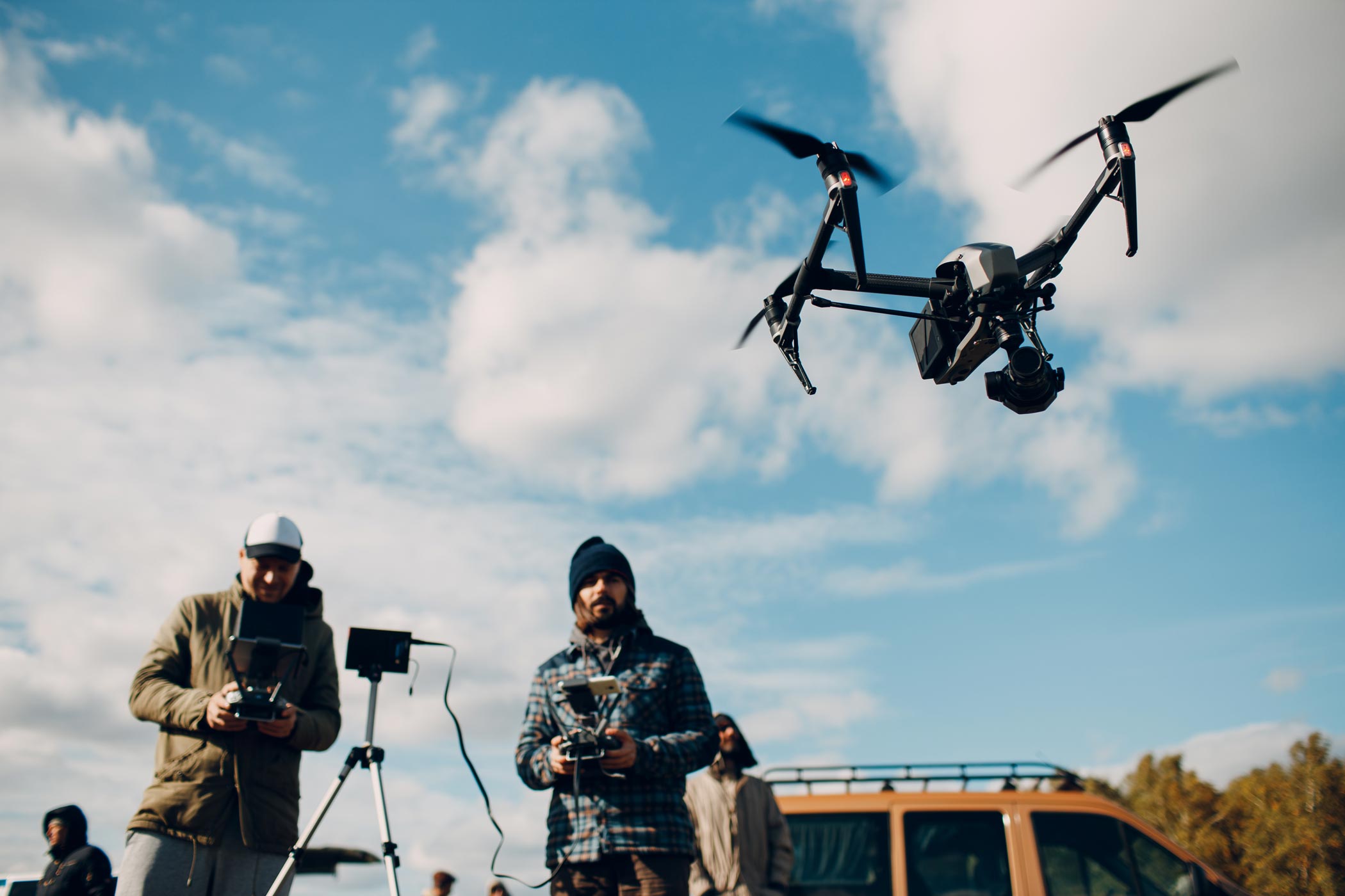 Professional cinema drone with camera gimbal in flight against a cloudy sky