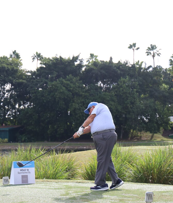 A golfer follows through on a tee shot at the 2025 Victoria Venezuela Foundation charity golf tournament.