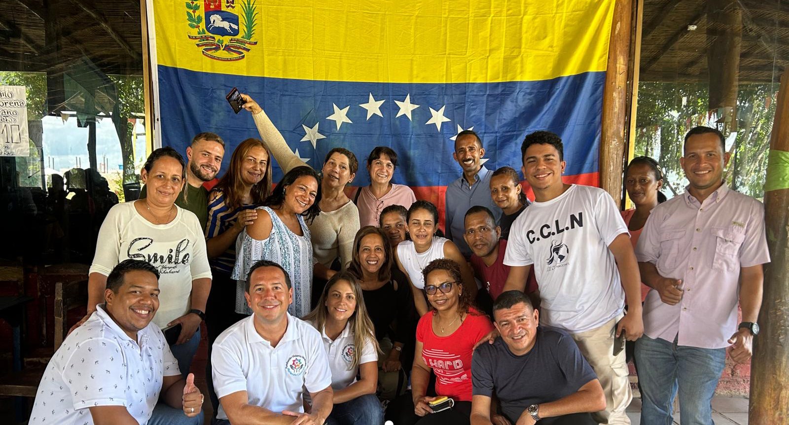 Victoria Venezuela Foundation volunteers and staff together in front of a Venezuelan flag during a mission trip.