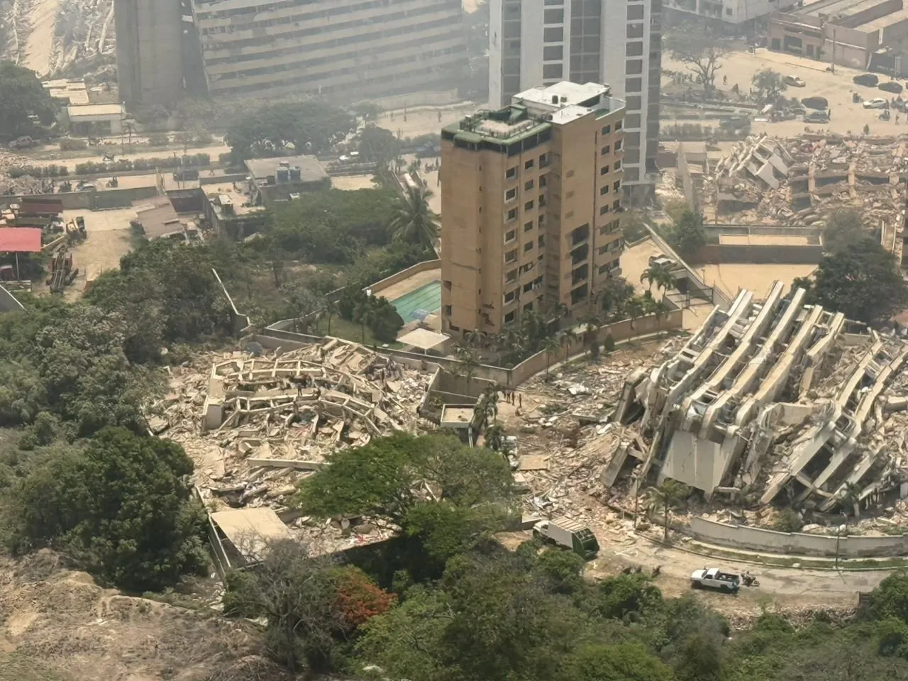 Aerial view of an apartment tower beside buildings that collapsed in the earthquakes.